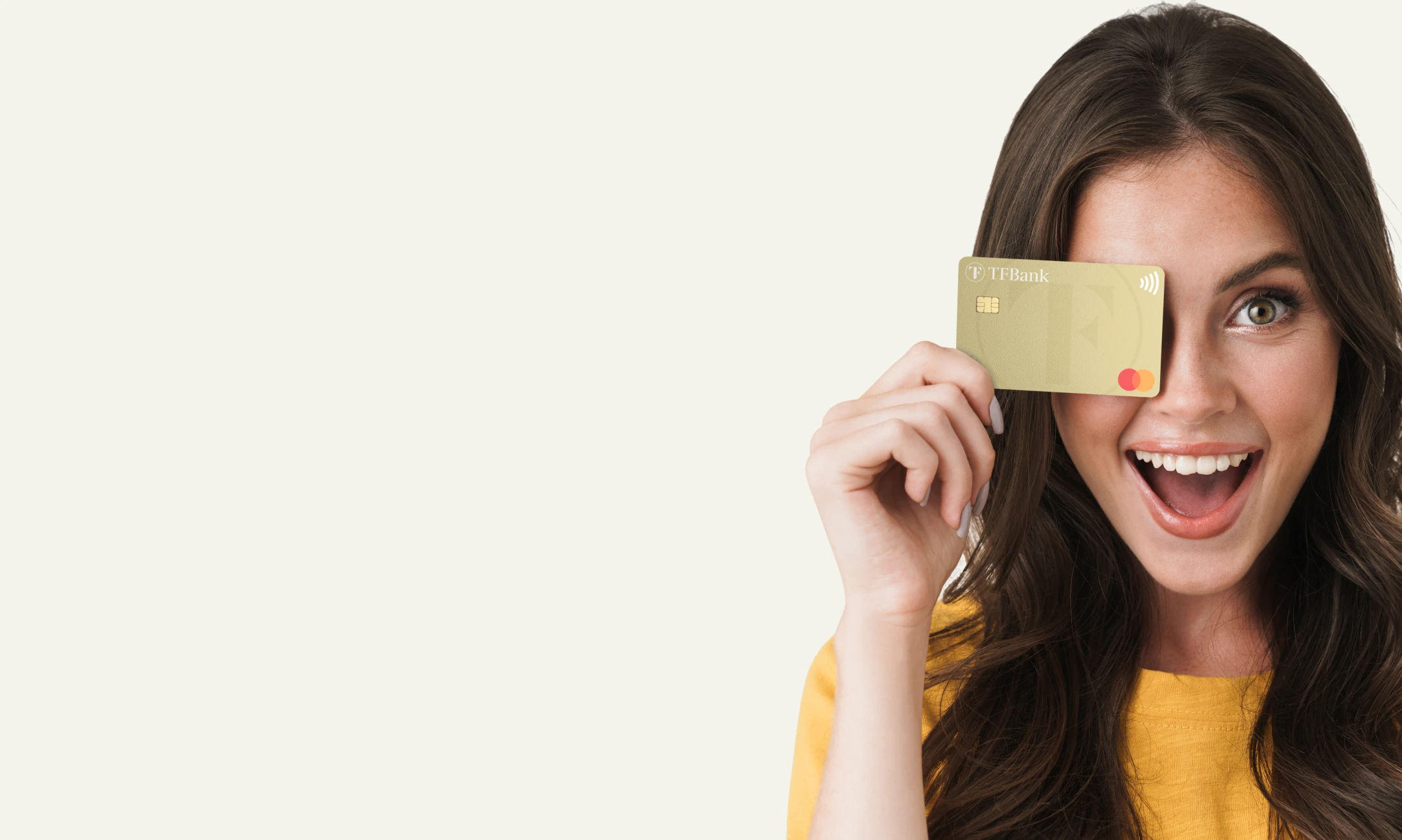 Ragazza sorridente con capelli scuri e occhi azzurri che tiene in mano una TF Mastecard Gold. 